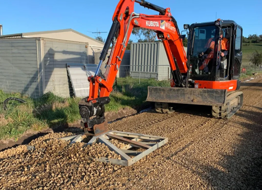 Orange excavator digging ground.